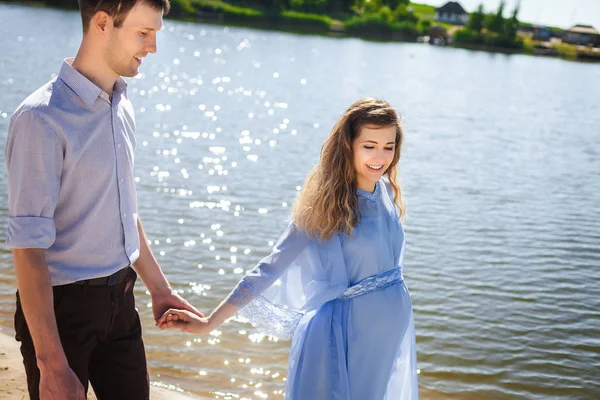 Framtida mamma och pappa gå nära lake — Stockfoto
