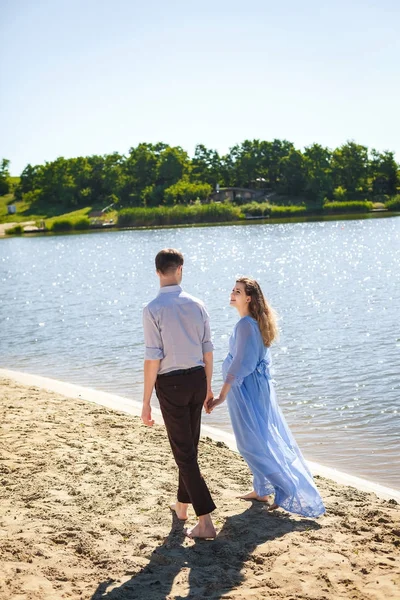 Zukünftige Mutter und Vater gehen am See Hand in Hand — Stockfoto