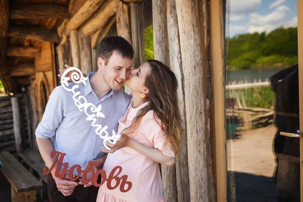 Zukünftige Mama und Papa küssen sich auf Holzterrasse — Stockfoto