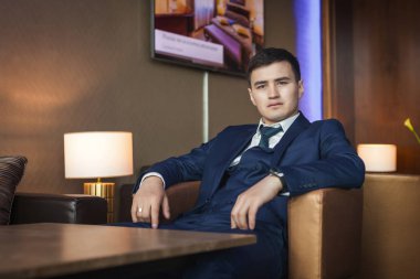 Otel sandalyede oturan damat