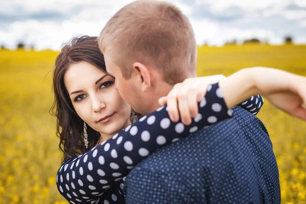 Mädchen und Junge umarmen sich auf gelber Wiese — Stockfoto