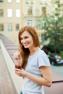 Sokağın ortasında kokteyl içme Kızıl saçlı kadın