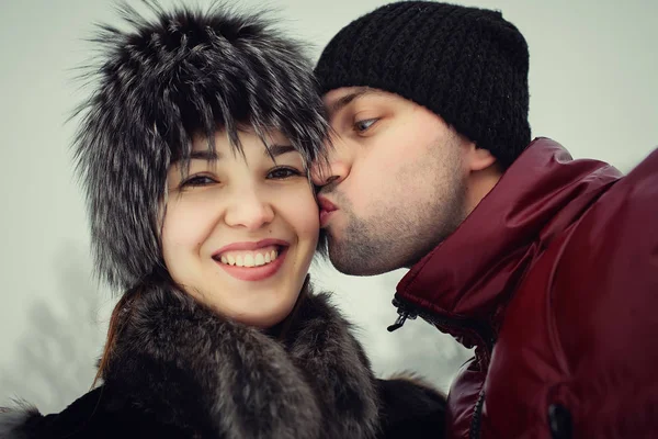 Hombre y mujer besándose en el parque de invierno — Foto de Stock