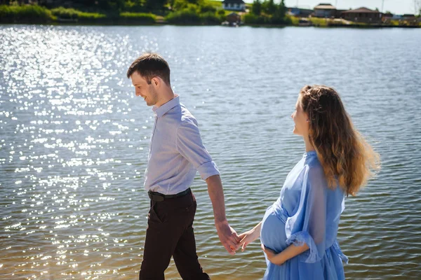 Framtida mamma och pappa gå på floden kusten — Stockfoto