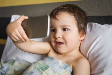 selfie sabah yatakta yatıyordu telefon alarak akıllı yakışıklı