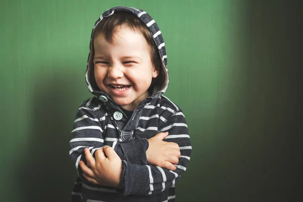 Garoto bonito sorrindo menino cruzando as mãos em pulôver — Fotografia de Stock