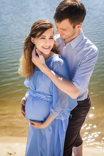 Framtida mamma och pappa kramar i naturen — Stockfoto