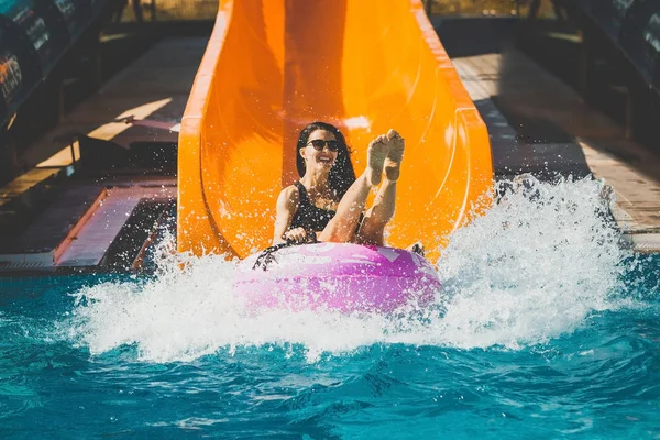 woman coming down by the slide in aqua park