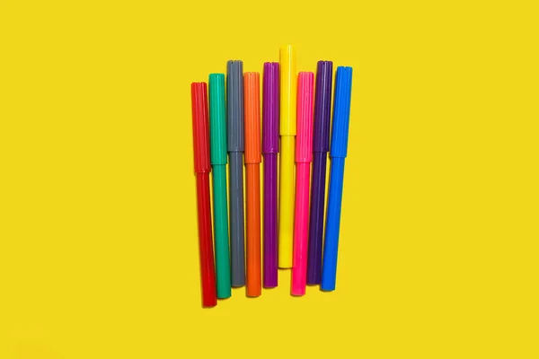 노란 배경에 놓여 있는 여러 가지 색깔의 펠트 펜들 — 스톡 사진