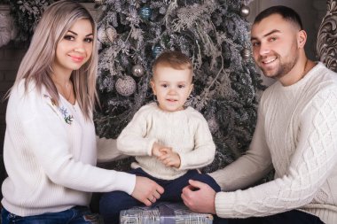 Anne ve baba çocuğu kucaklıyor.