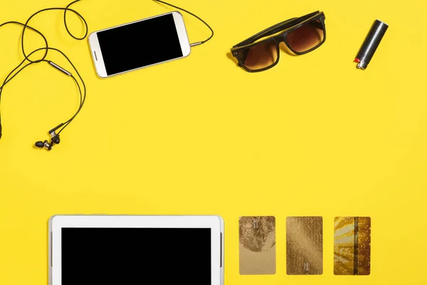 set of modern gadgets and accessories on a yellow background