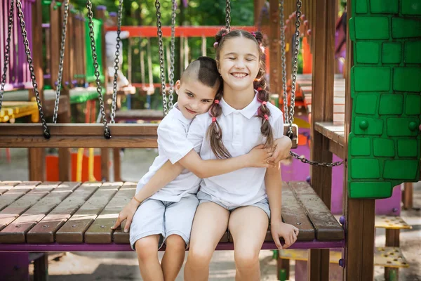 brother hugging sister at the playground