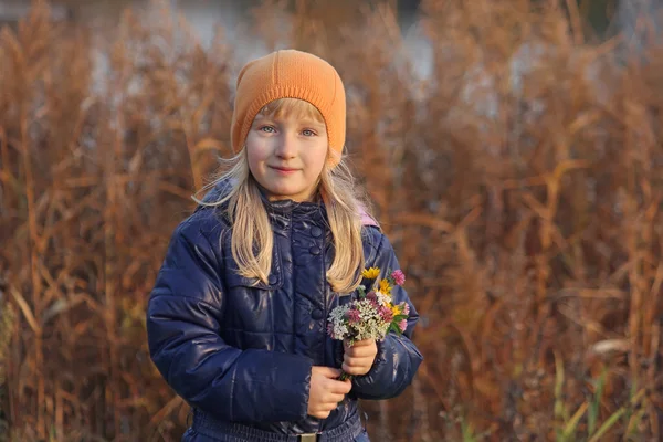 Krásná blond dívka sbírá kytice lučních květin. Podzim. — Stock fotografie