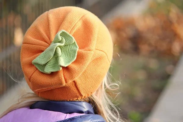 Knitted autumn orange hat in the form of a pumpkin. Clothes for Halloween.