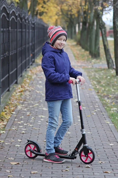  Bir scooter üzerinde bir yürüyüş ile örgü şapkalı kız