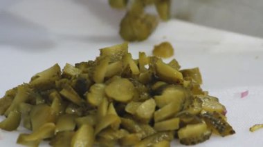 Hızlı bir şekilde bir bıçak turşu turşusu kesip eldivenlerle yemek. Yakın çekim.