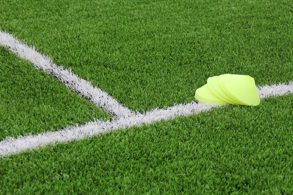 Patatas fritas en un césped artificial con marcas en un campo de fútbol. Fondo deportivo . — Foto de Stock