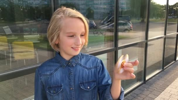 Indah gadis sekolah ceria bermain dengan pemintal gelisah emas. Mainan trendi yang populer . — Stok Video