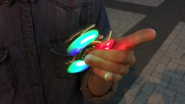 Luminoso fidget spinner en la mano. Popular juguete de moda primer plano . — Vídeos de Stock