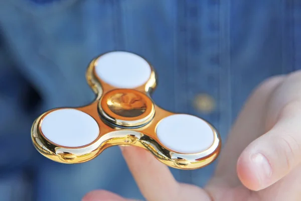 Gold fidget spinner in hand. Popular trendy toy close-up. — Stock Photo, Image