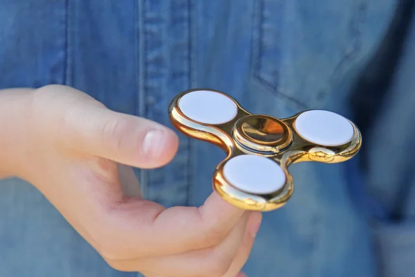 Gold fidget spinner in hand. Popular trendy toy close-up. — Stock Photo, Image