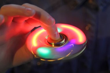 Işık kıpır spinner elinde. Popüler moda oyuncak yakın çekim.