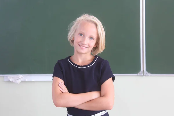Porträt eines glücklichen Schulmädchens im Alter von 9-11 Jahren in einem Klassenzimmer in der Nähe einer Tafel. Zurück zur Schule. — Stockfoto
