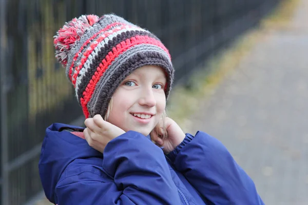 Fröhliches Mädchen mit einer warmen Strickmütze für einen Spaziergang — Stockfoto