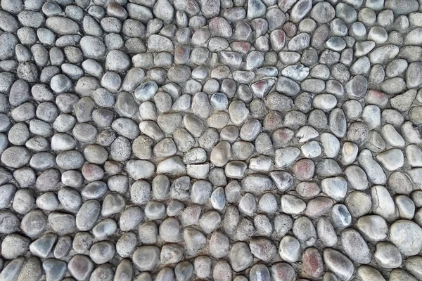 Un viejo muro de piedra. Piedras ásperas de diferentes formas. Fondo de piedra . Imagen De Stock