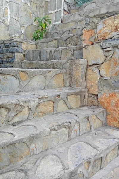 Uma velha escada de pedra entre as paredes de pedra. Escadas feitas de pedras de diferentes formas e tamanhos . — Fotografia de Stock