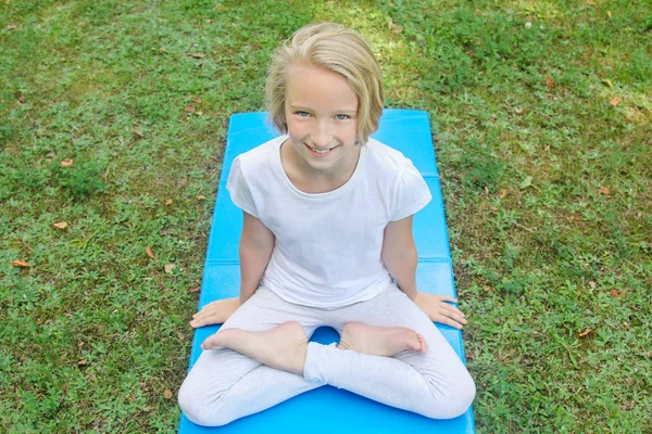 Vacker Blond Preteen Flicka Lätta Kläder Öva Yoga Matta Parken Stockbild