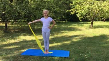 Güzel okul spor bir lastik bant ve mat açık havada parkta oynarken çocuk kız arası. Sağlıklı bir yaşam tarzı. Açık havada egzersiz. 