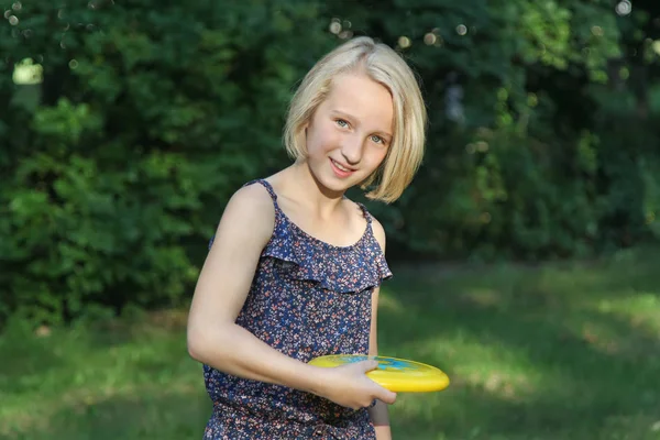 美丽的金发女孩玩飞盘在公园 户外活动运动游戏 — 图库照片