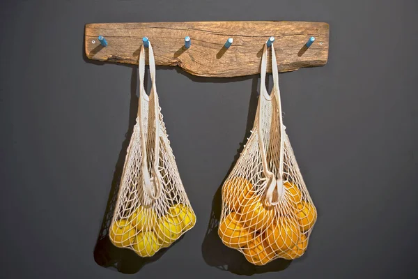 String bags with citrus fruits. 스톡 사진