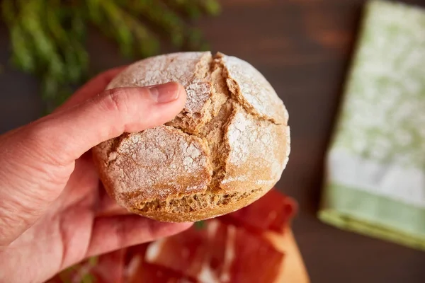 Pane appena sfornato fatto a mano nella mano. Timo verde fresco e peperoncino piccante. Bacon succulento su una tavola di legno . — Foto Stock