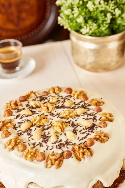 Μια μεγάλη νόστιμη πίτα με καρύδια. Σπιτική πίτα με λευκή σοκολάτα και επικάλυψη μάρκες σε ένα λευκό ξύλινο τραπέζι. — Φωτογραφία Αρχείου