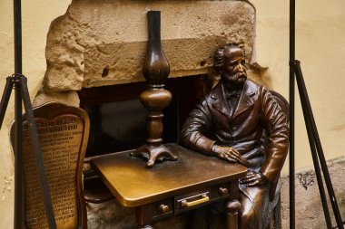 Lviv, Ukrayna - Kasım, 2017. Lviv gaz lambası kurucusu anıt. Bir masada oturan adam bronz heykeli