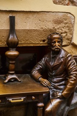 Lviv, Ukrayna - Kasım, 2017. Lviv gaz lambası kurucusu anıt. Bir masada oturan adam bronz heykeli