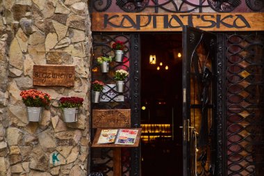 Lviv, Ukrayna - Kasım, 2017. Işıklar içinde belgili tanımlık geçmiş ile Karpatska Restoran girişinde. Bir metal Ferforje kapı ahşap işaretiyle
