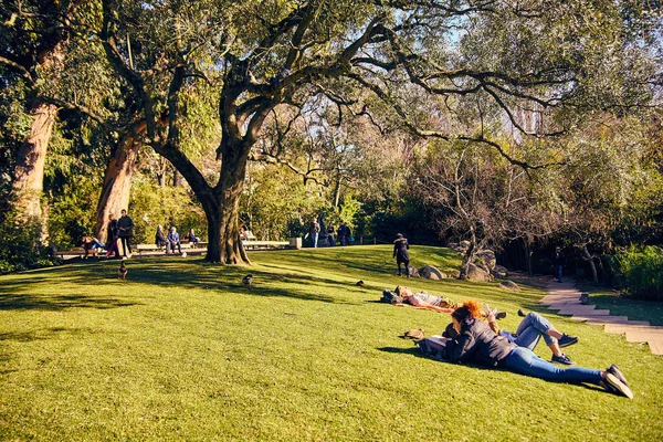 Lisbon, Portugal - January, 2018. Gulbenkian park and garden. People relax in the garden and enjoy sunny weather. Families came to the park on holiday for the weekend and to make picnic in the garden. — Stock Photo, Image
