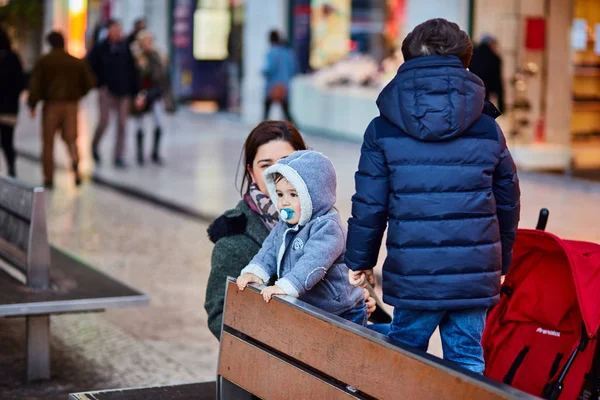 Lisboa, Portugal - enero de 2018. Un niño pequeño con un chupete en la boca está de pie en el banco y sonriendo . —  Fotos de Stock