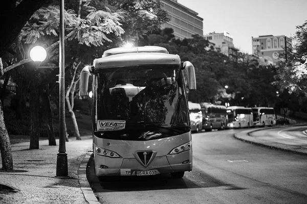 Lisbon, portugal - januar, 2018. ein großer touristischer bus der marke volvo auf einem parkplatz in der stadt in der nähe der straßenlaterne. Schwarz-Weiß-Fotografie bei Nacht. — Stockfoto