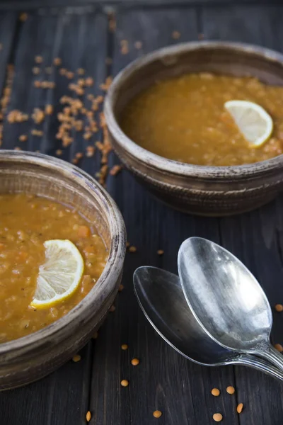 Чечевичный суп с чесноком и лимоном в глиняных тарелках — стоковое фото