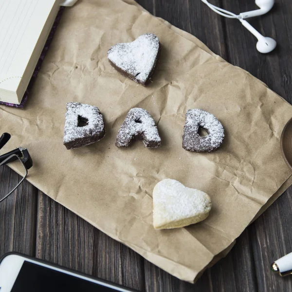 Happy Den otců pozdravy. soubory cookie a kávu na ploše — Stock fotografie
