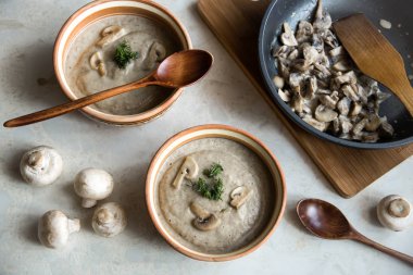 Kremalı mantar çorbası iki öğle yemeği için. tahta kaşık ve mantar ile kızartma tavası