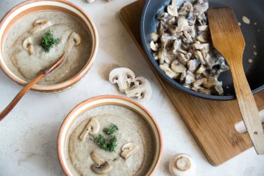 Kremalı mantar çorbası iki öğle yemeği için. tahta kaşık ve mantar ile kızartma tavası