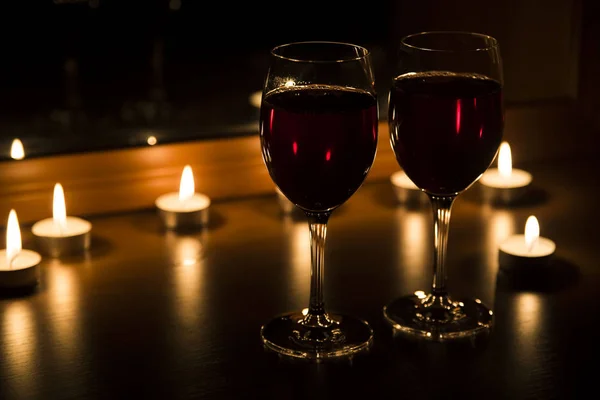 Velas e um copo de vinho em casa à noite — Fotografia de Stock