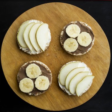 muz ve fıstık ezmesi, peynir ve armut dairesel somun buğday üzerinde tatlı sandviç. Üstten Görünüm