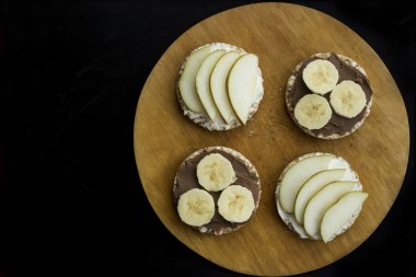 muz ve fıstık ezmesi, peynir ve armut dairesel somun buğday üzerinde tatlı sandviç. Üstten Görünüm