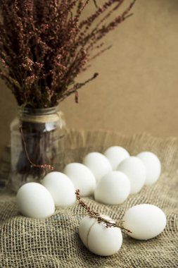 Beyaz yumurta kuru çiçekler ve pembe ip ile dekore edilmiş